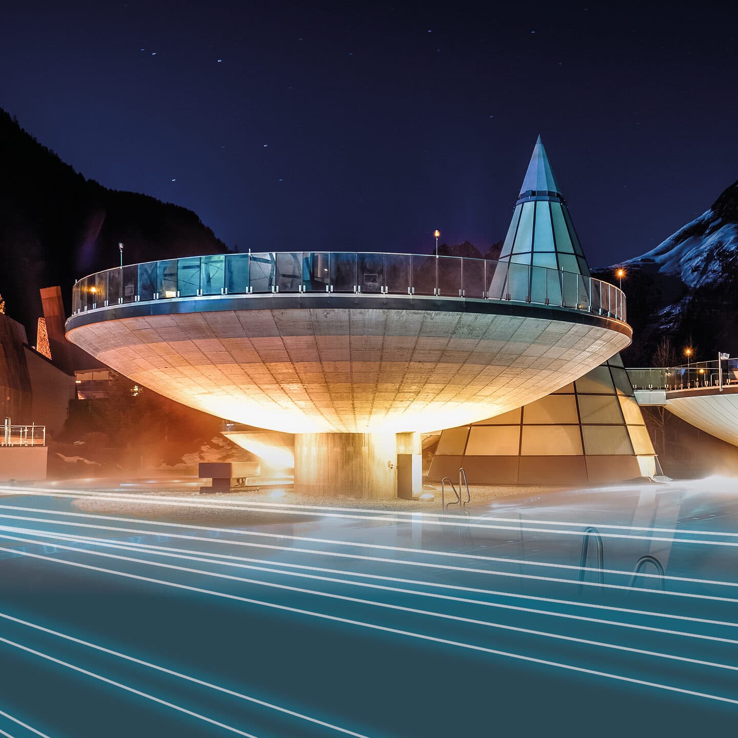 Modern, illuminated building with a circular platform and cone-shaped glass structure, set against a nighttime mountain backdrop with glowing lines in the foreground.